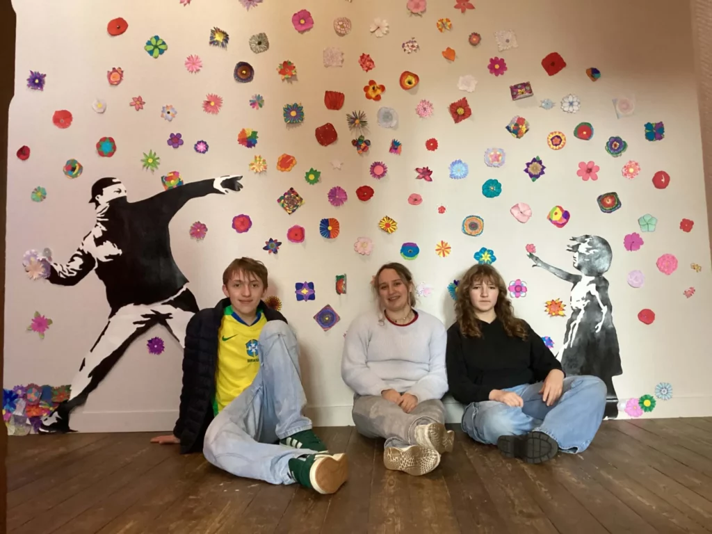 Élèves en atelier d'arts plastiques devant leurs créations murales