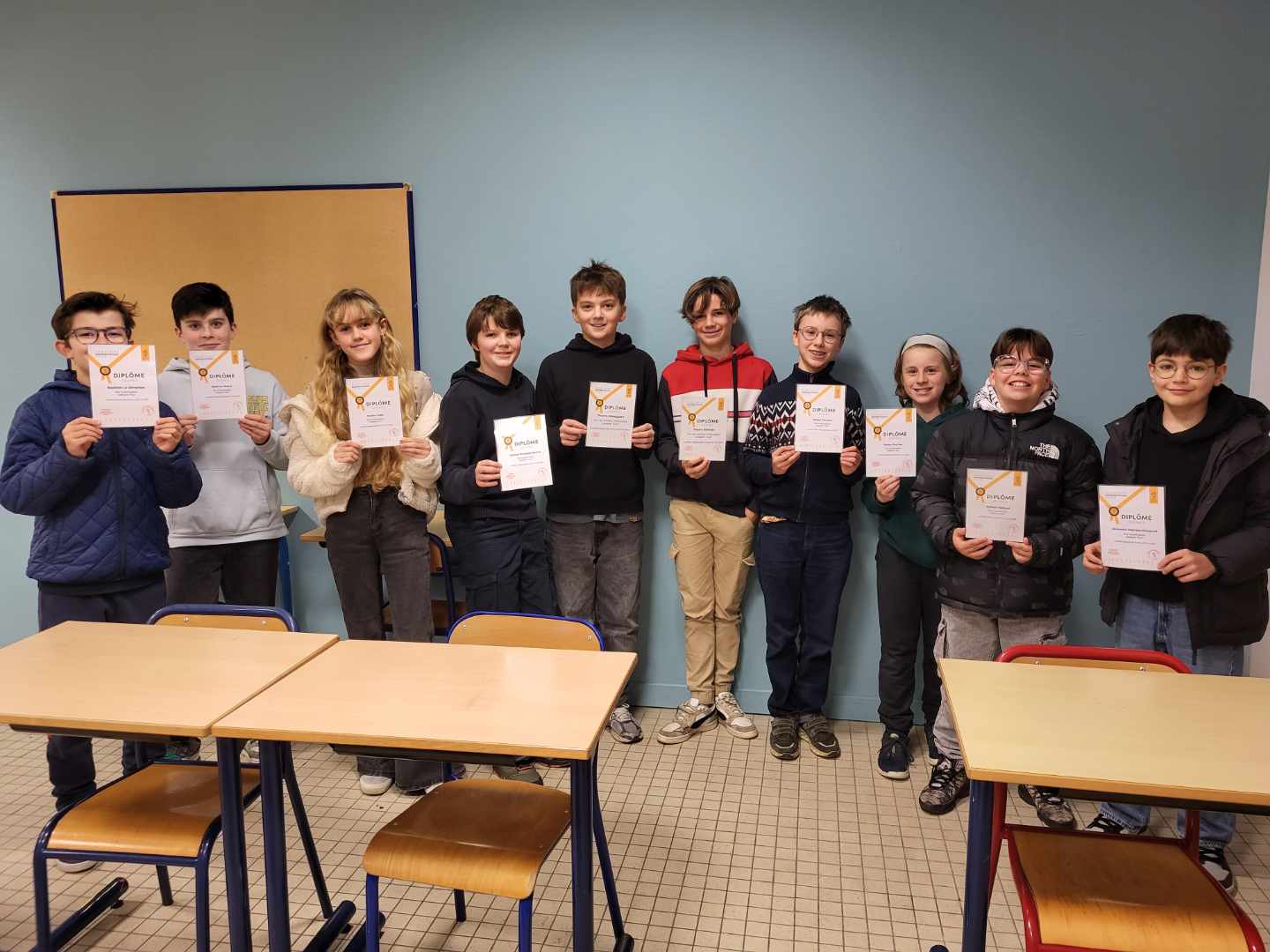 Groupe d'élèves tenant leurs prix à l'occasion d'une compétition d'échecs, souriant face à l'objectif.