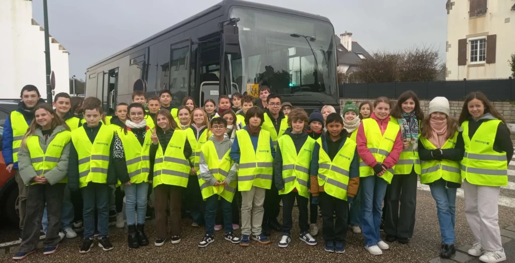 Élèves de 6ème en gilets jaunes devant un car, lors d'une action de sensibilisation à la sécurité routière.
