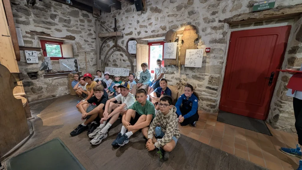 Des élèves observent le fonctionnement du moulin de Keriolet lors de leur visite.