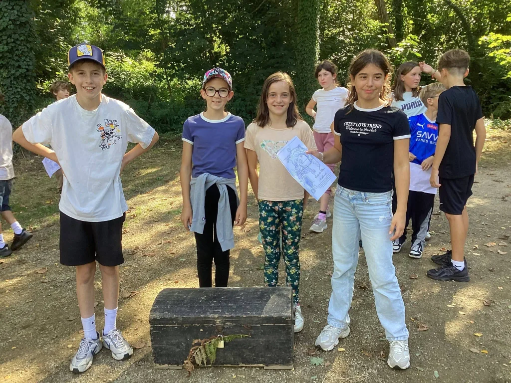 Un groupe d’élèves de 6e devant le coffre découvert pendant la chasse au trésor de la journée de rentrée.