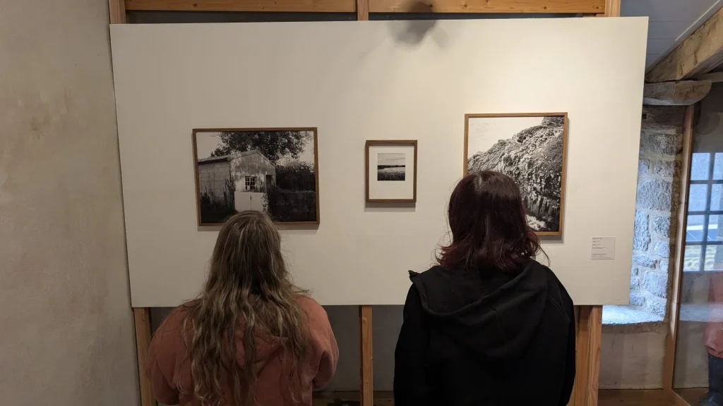 Deux élèves découvrant les photographies de Bastien Duval lors de l’exposition au Marquisat de Pont-Croix.
