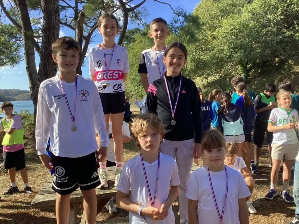 Groupe d'élèves médaillés réunis à l'ombre des arbres après les courses