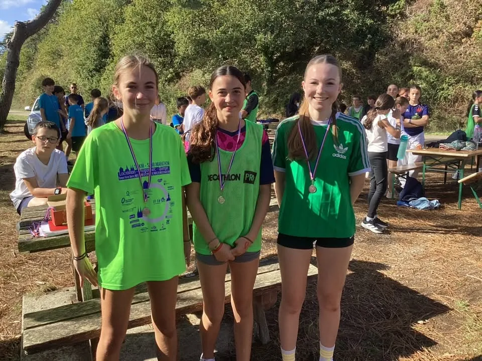 Trois collégiennes portant leurs médailles après la compétition sportive