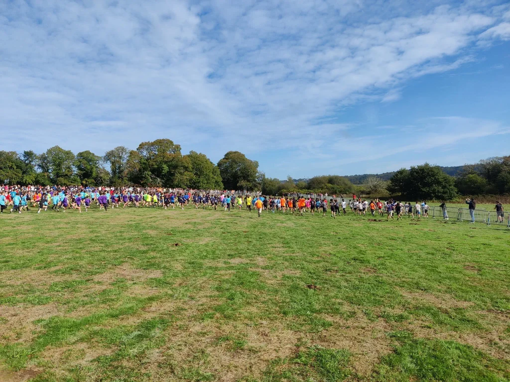 Départ groupé des jeunes coureurs lors du cross départemental UGSEL au Corniguel, à Quimper, sur un vaste terrain enherbé.